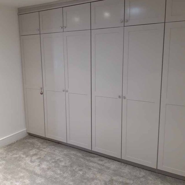 A fully fitted dressing room with additional storage above